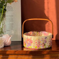 Pink ceramic fruit basket with floral pattern, 6 inches, on tea table with fruit