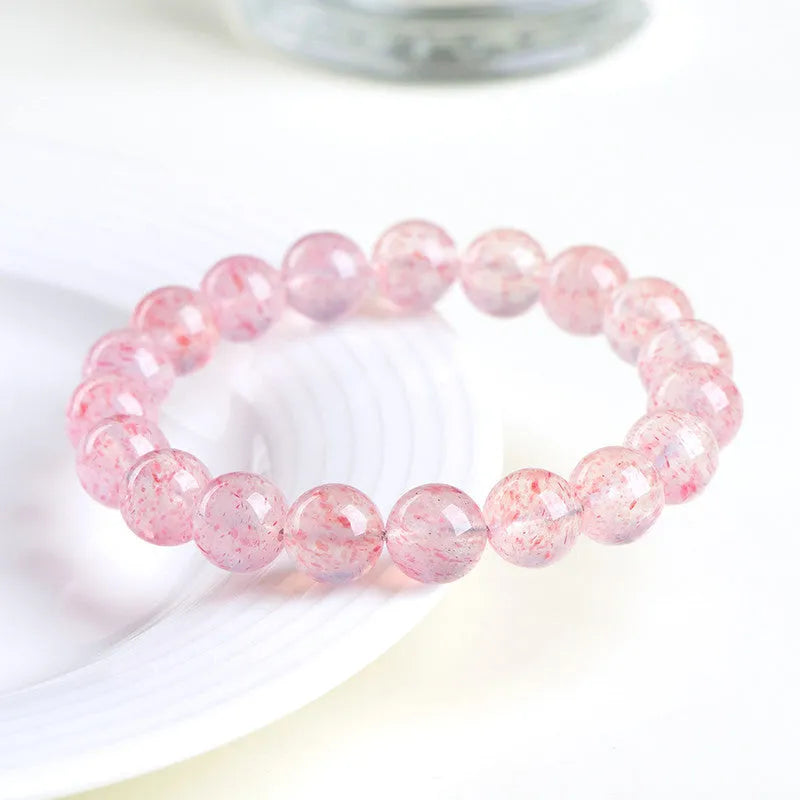 Natural strawberry quartz crystal bracelet with white water geometric beads on elastic cord.