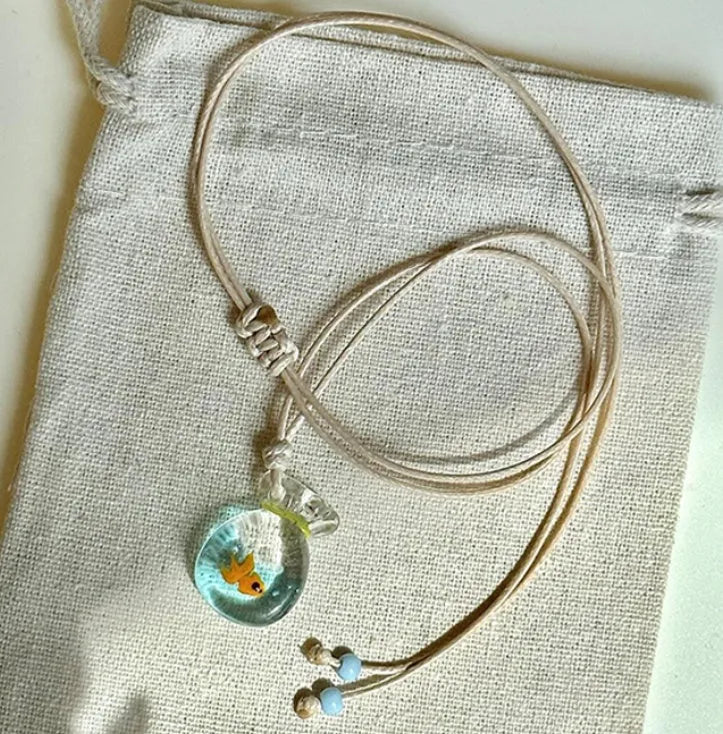 Women's joker pendant necklace with coloured glaze charm on a cotton and linen clavicle chain.