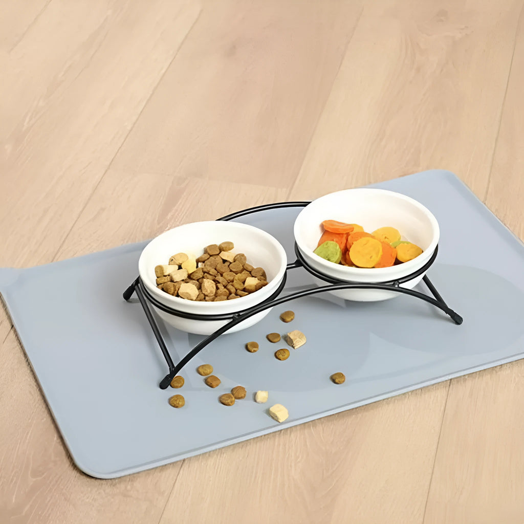 Silicone pet placemat under a dog bowl in grey colour on a kitchen floor.
