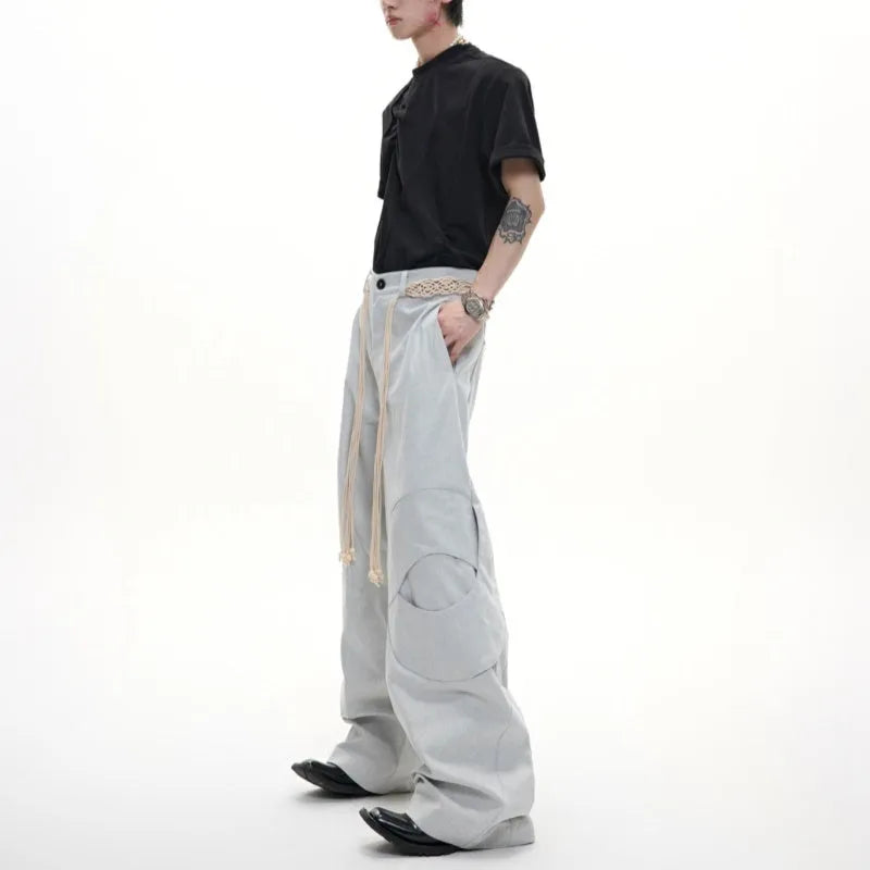 Man's dark blue straight-leg cotton trousers with belt stitching and zipper details on a loose fit.