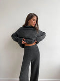 Women's dark grey casual suit with side-slit sweater top and matching trousers.