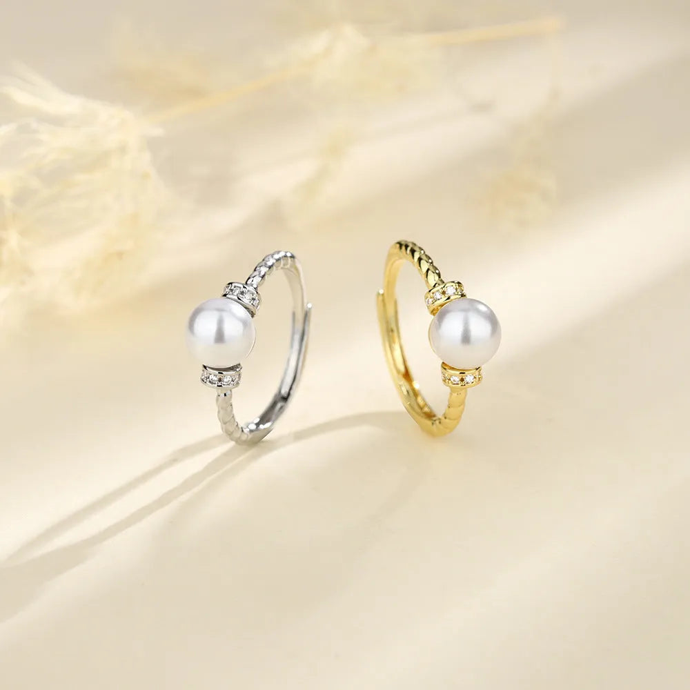 Adjustable copper ring with pearl inlay in gold or silver finish and antique twist design.