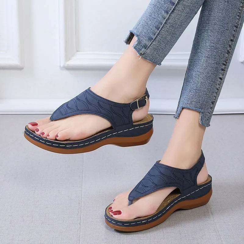 Women's red casual wedge heel sandals with an adjustable buckle strap on a white background.