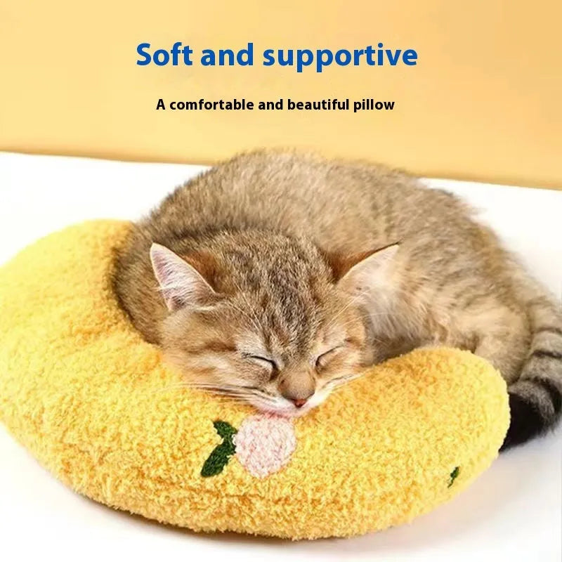 Blue U-shaped cat sleeping mat with integrated moon-shaped neck pillow on a wooden floor.