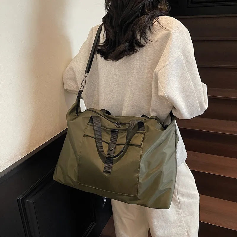 Grey one-shoulder travel bag made from Oxford cloth with a large capacity.