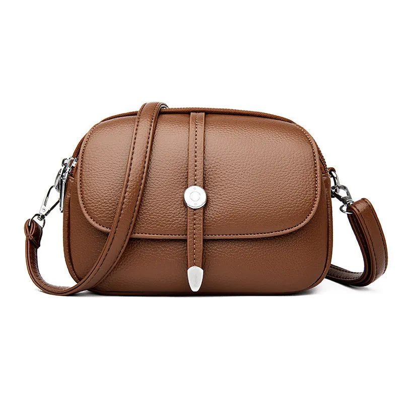 Women's oval crossbody shoulder bag in black, khaki or dark brown with visible sewing thread detail