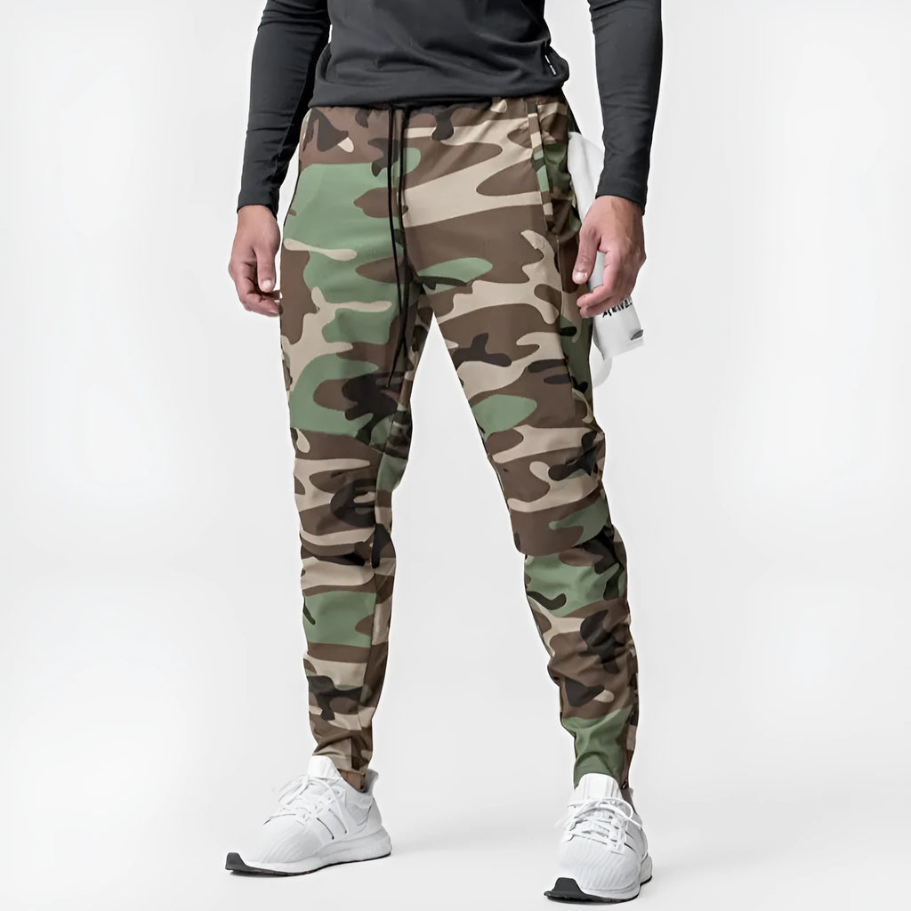 Man wearing loose grey running trousers with tied ankles, made from quick-dry polyester fabric.