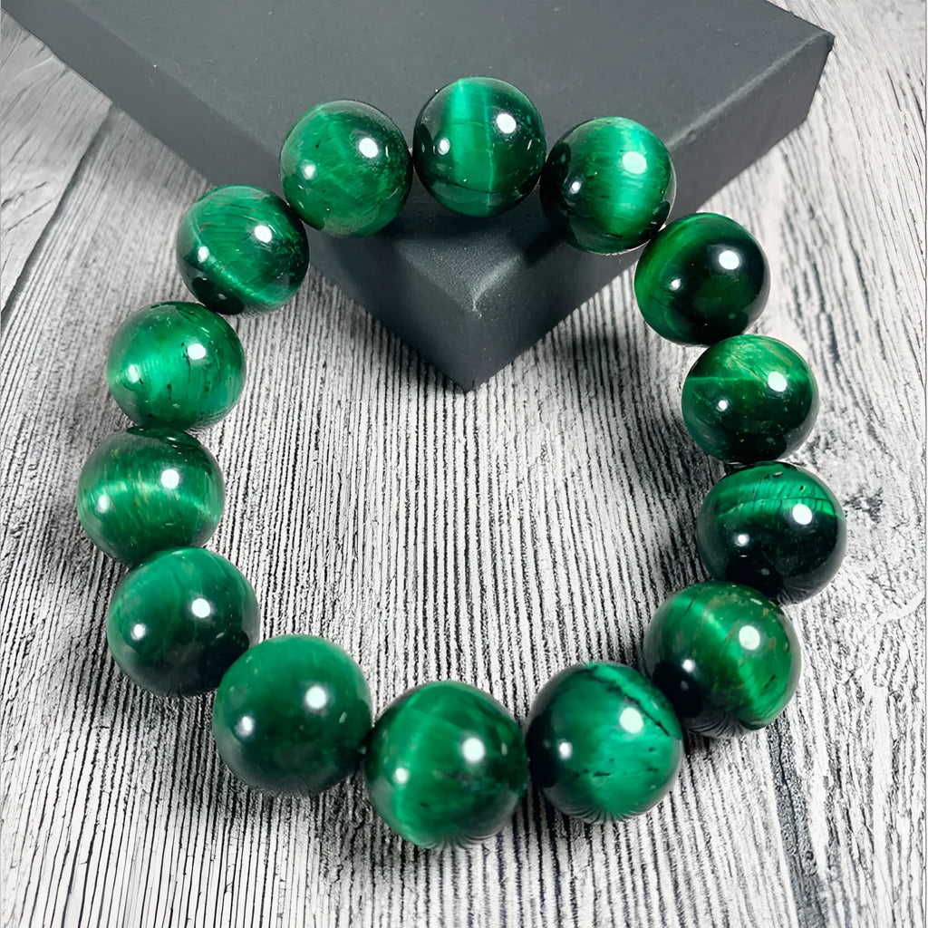Green tiger eye stone bracelet with geometric shaped beads on a white background.