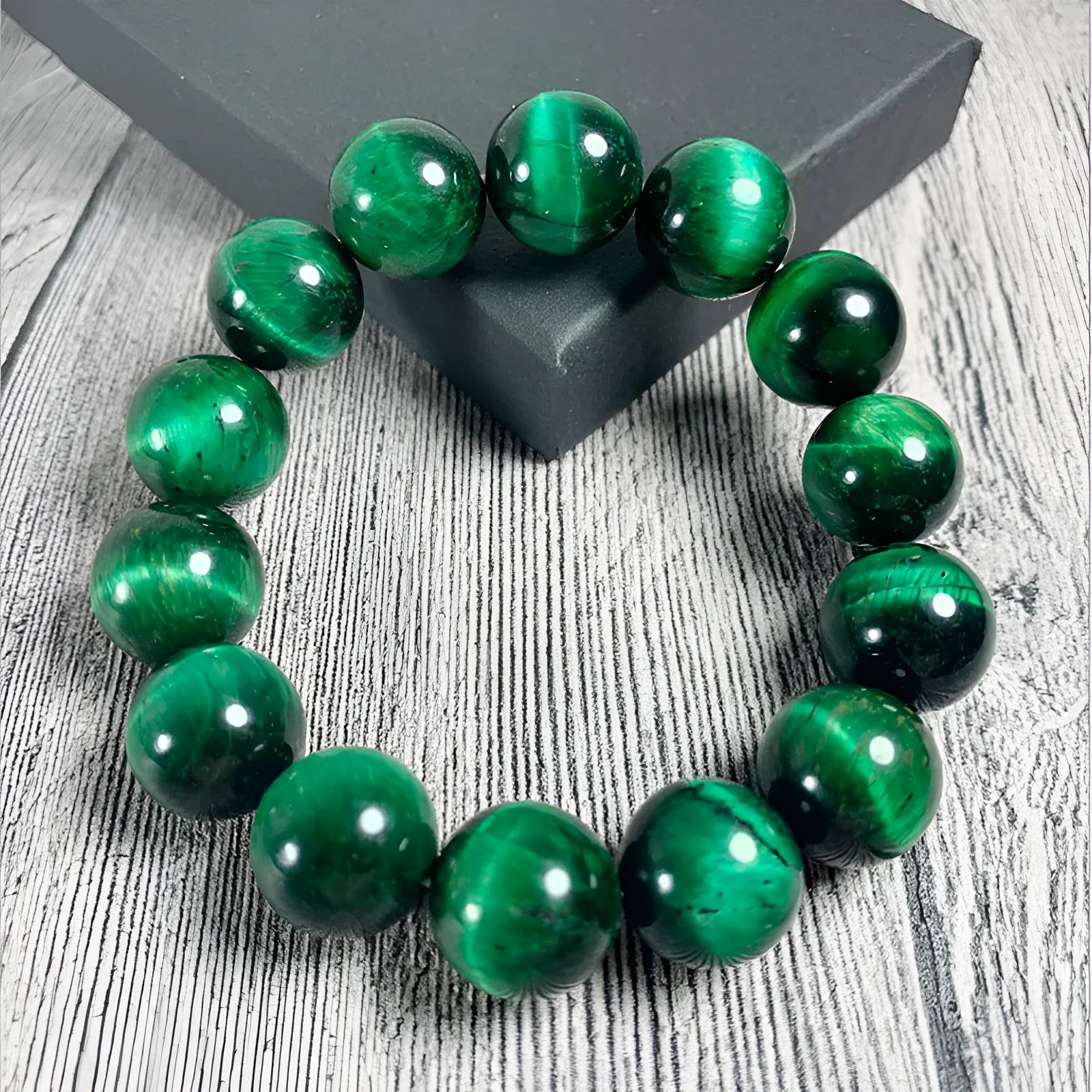 Green tiger eye stone bracelet with geometric shaped beads on a white background.