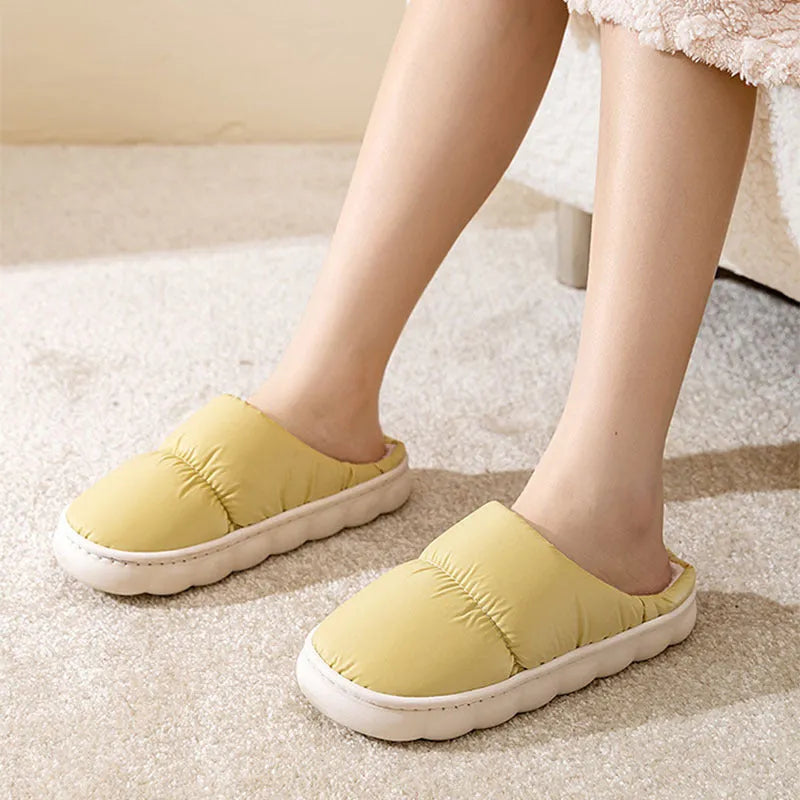 A pair of thick-soled down cotton slippers for men and women in a choice of colours, featuring a non-slip rubber sole.