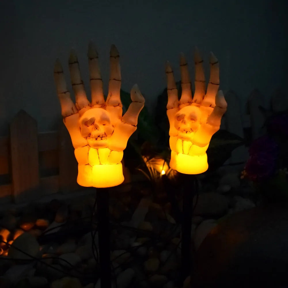 Halloween ghost hand solar light in garden setting with warm white glow, plastic IP55 waterproof construction