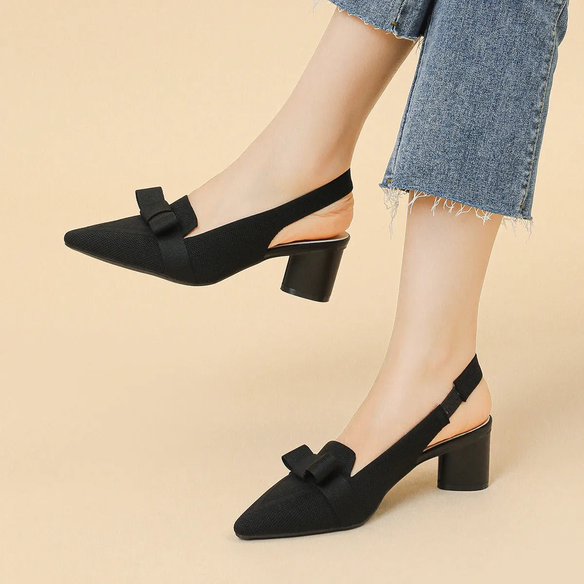 Women's closed toe high heel sandals with bow detail, ankle buckle strap, and pointed toe in a solid colour.