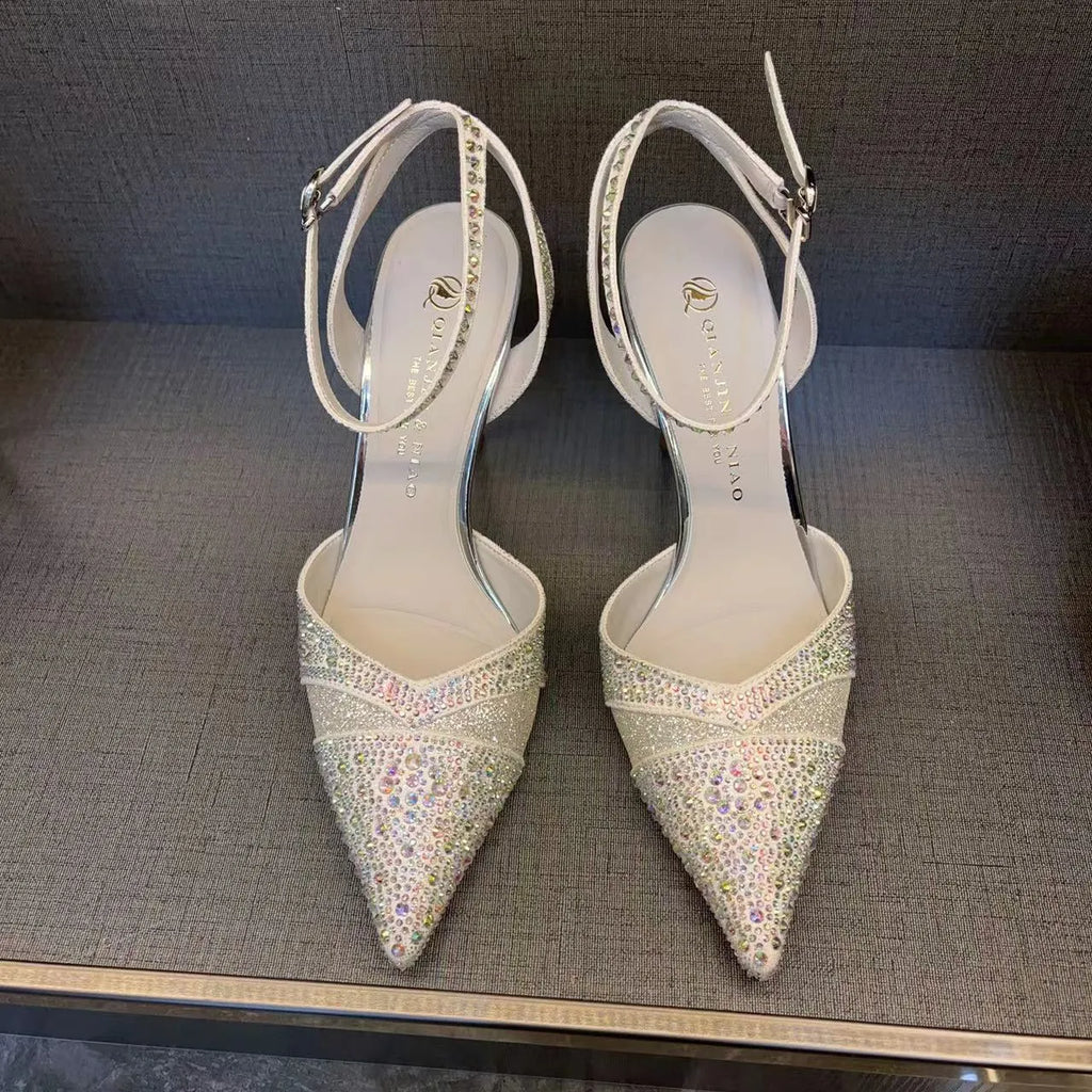 A pair of women's black hollow high heels with a red sole, stiletto heel, and pointed toe.