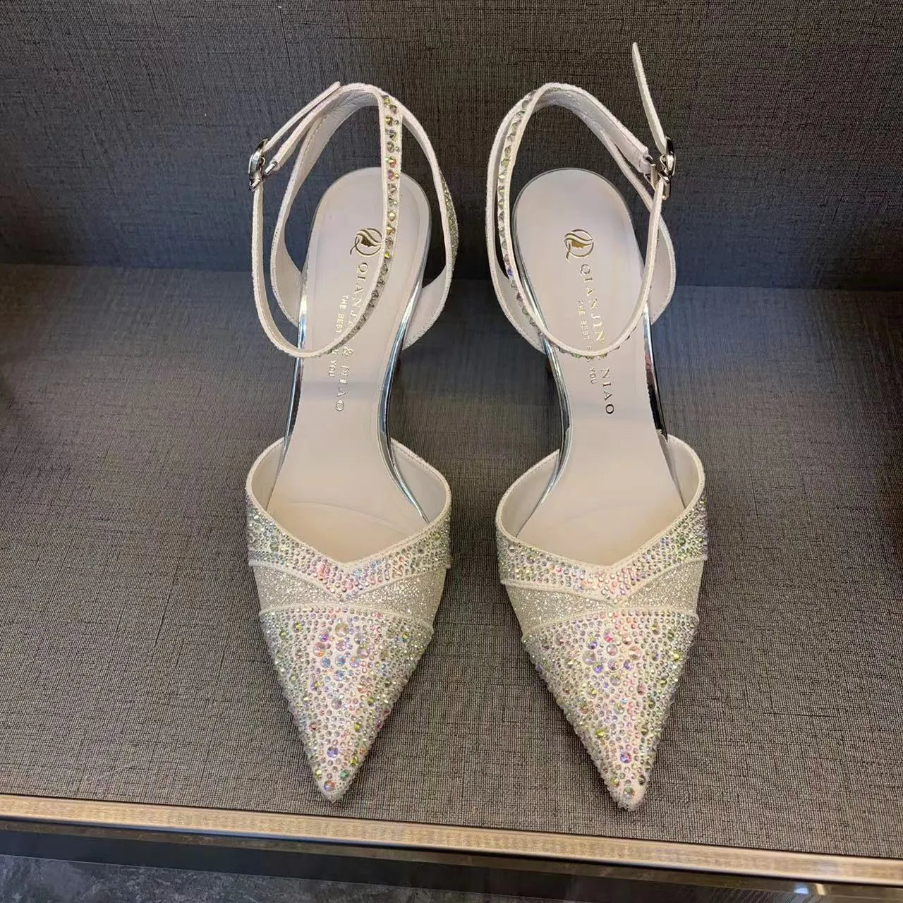 A pair of women's black hollow high heels with a red sole, stiletto heel, and pointed toe.