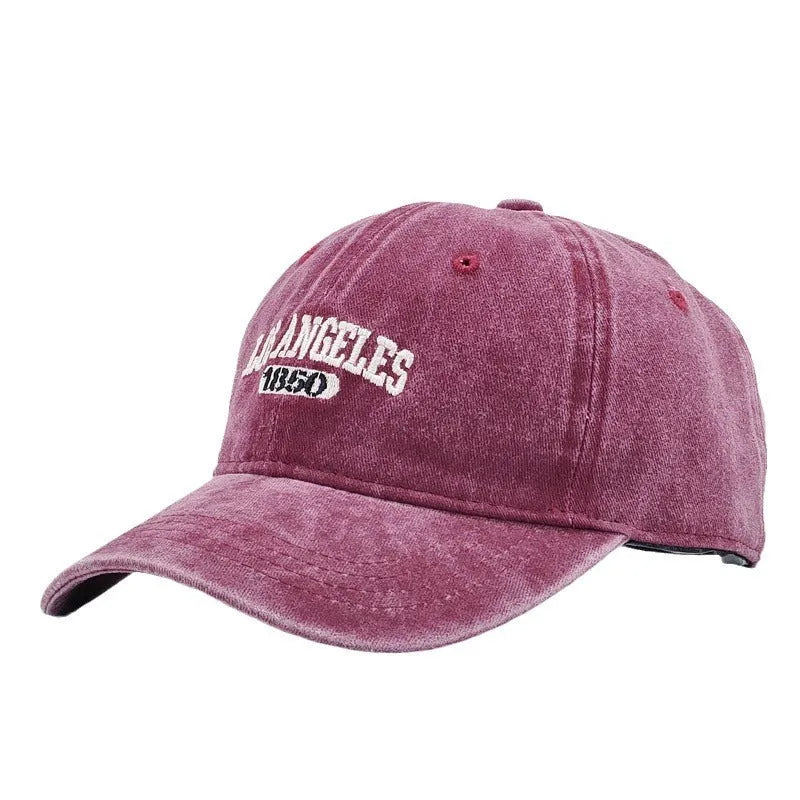Retro style acrylic peaked cap with distressed letter embroidery on the front, shown in beige colour.