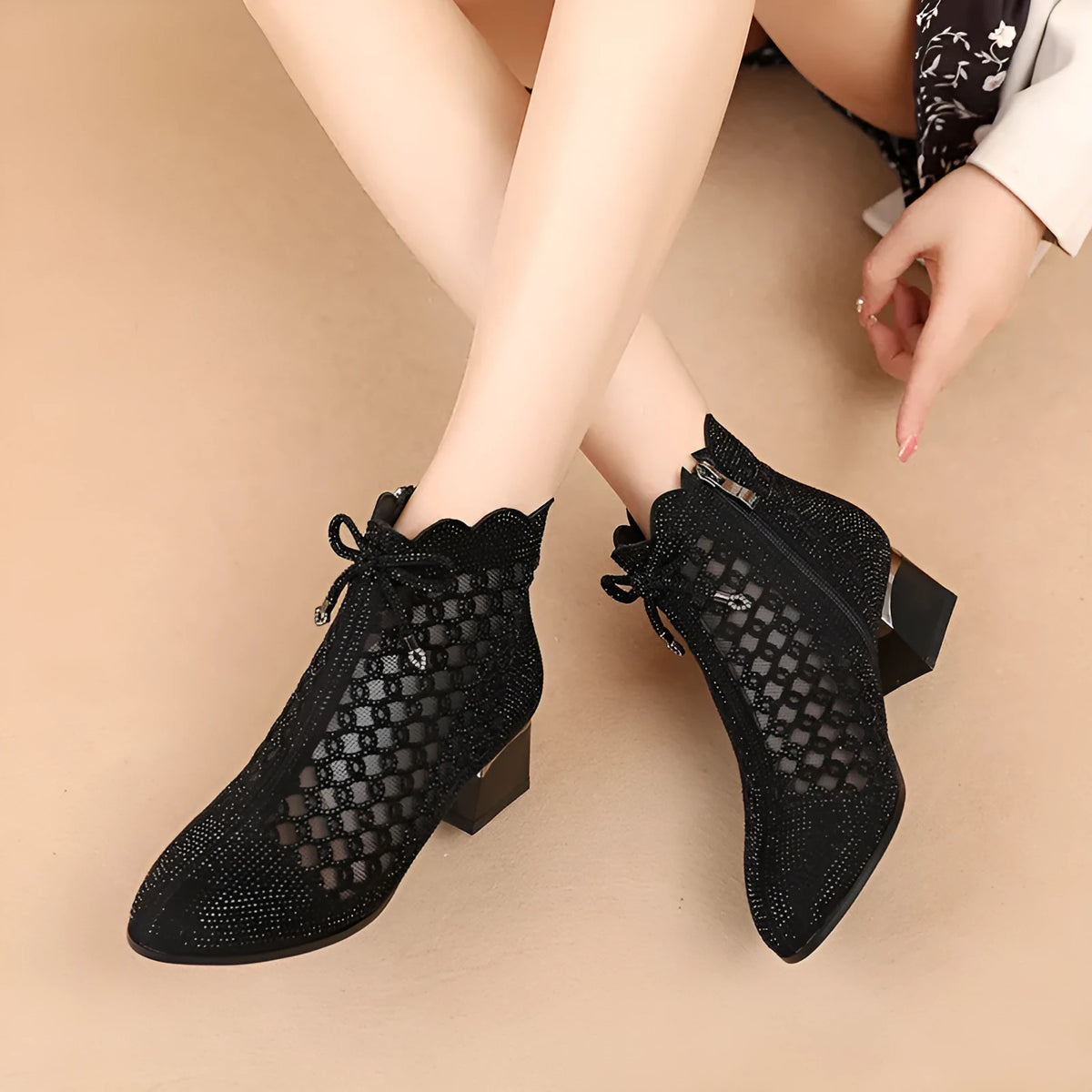 Women's black cutout mesh ankle boots with mid heel and rhinestone trim, side zipper closure