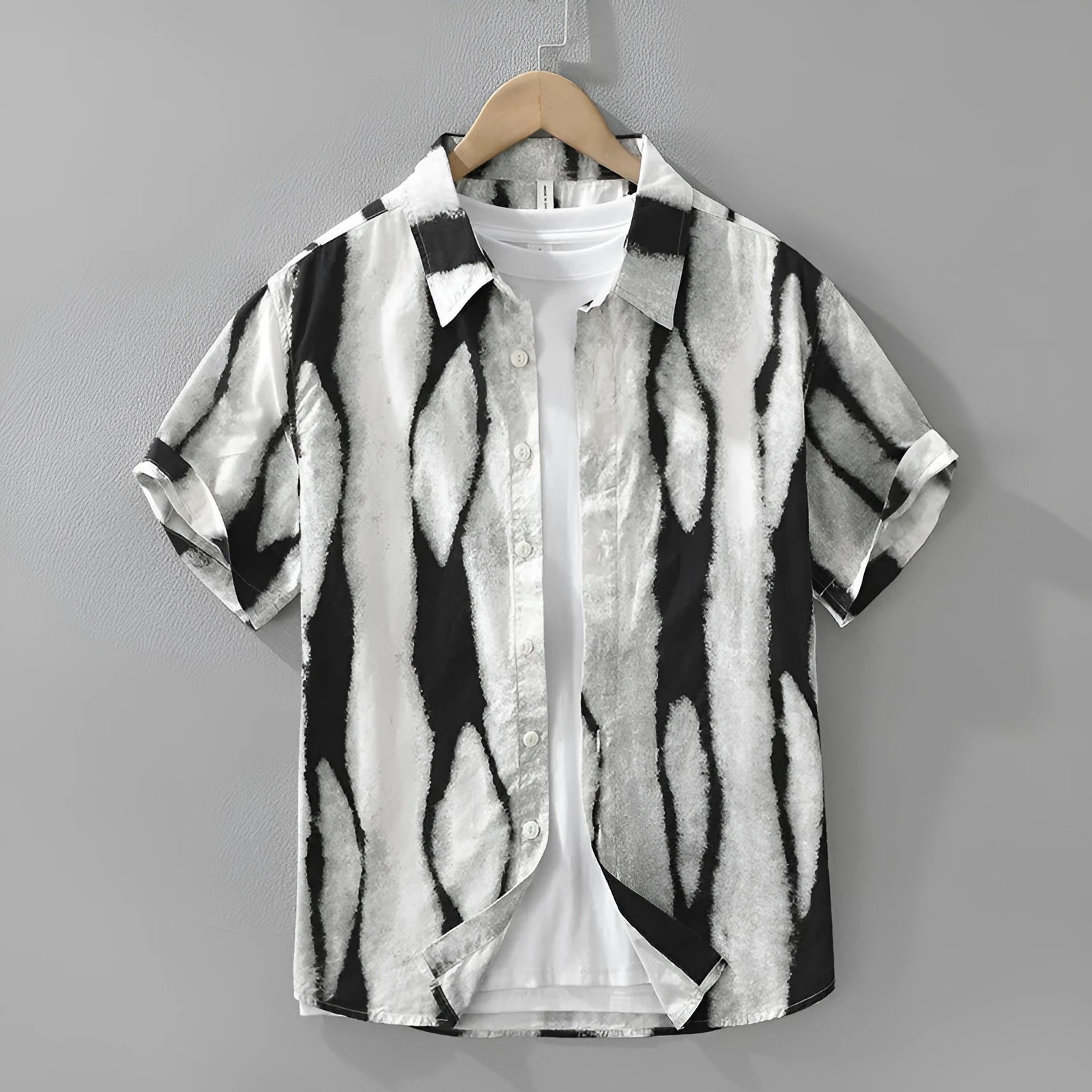 A man wearing a black and white striped loose-fit cotton cardigan-style short sleeve shirt.