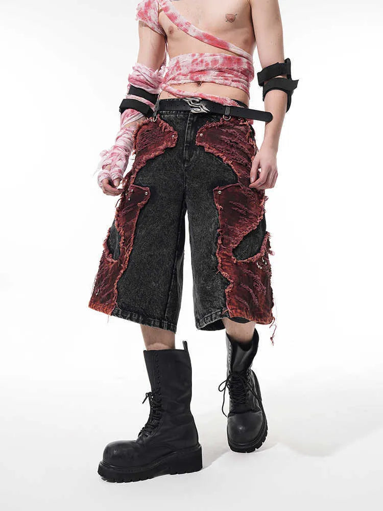 Distressed denim cropped pants with wide leg silhouette and brushed stitching details