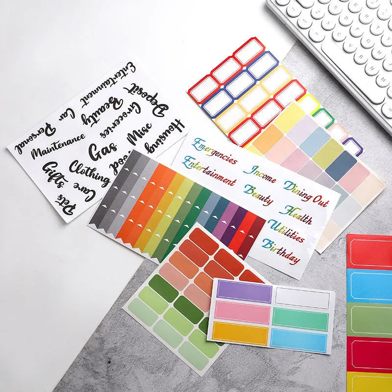 Assortment of handwritten labels, grid stickers, A6 rulers, and coloured sticky notes on a white background.