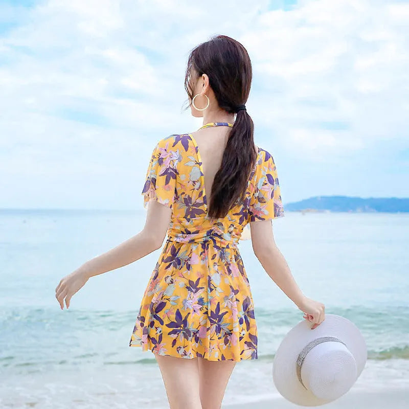 Yellow floral pattern women's one-piece swimsuit on a hanger showing front design