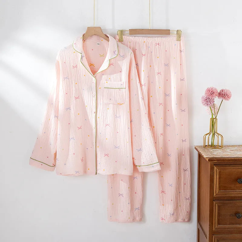 Women's beige long-sleeved cotton pajama top and trouser set laid flat.