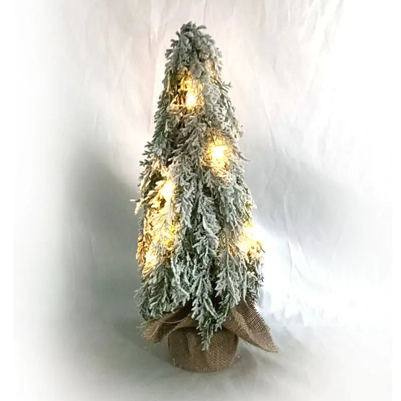 Small 24-inch frosted artificial Christmas tree with LED lights on a desktop.