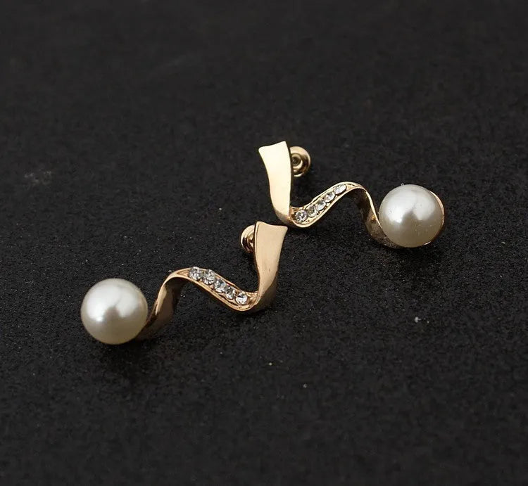 Gold electroplated pearl necklace and drop-shape earrings set on a jewellery display.