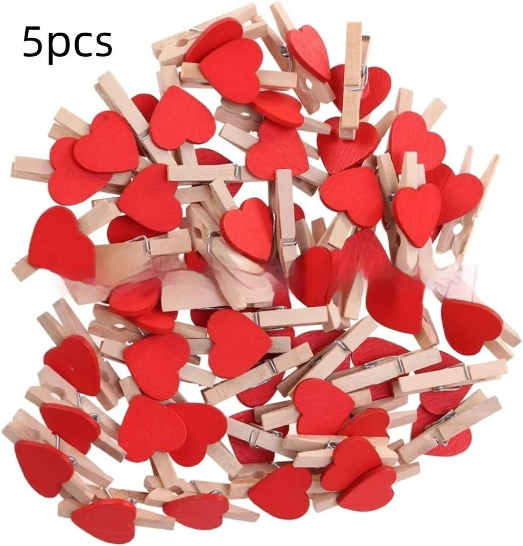 Five small wooden heart-shaped clips in red, pink, yellow, white, and rose red colours on a neutral background.