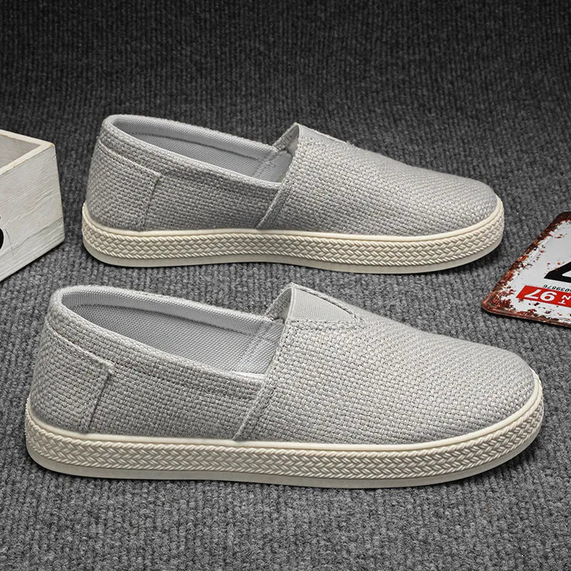 Men's beige linen cloth shoes with canvas upper and PVC sole on a plain background.