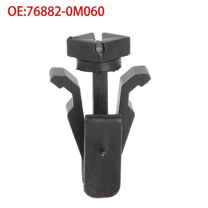 Black plastic Nissan bumper and grille fastening clip, model 76882-0M060.