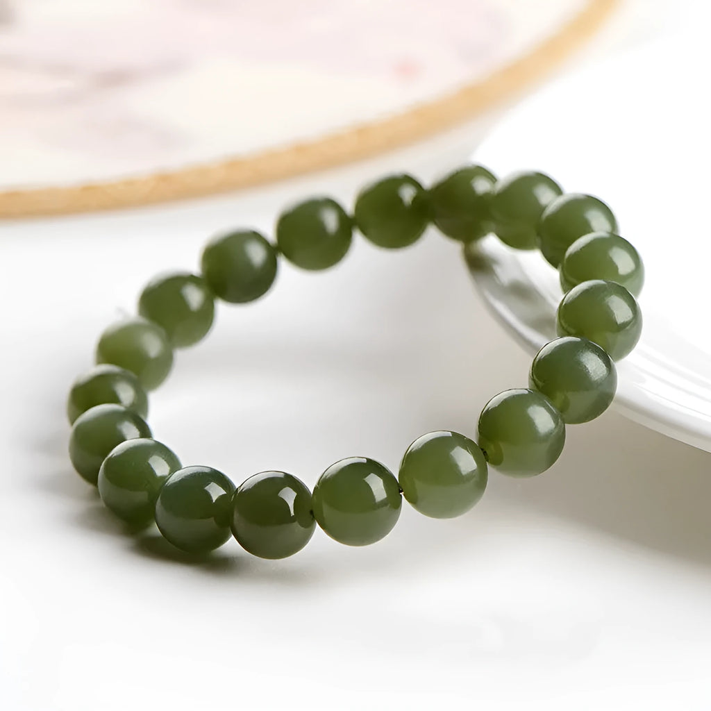 Polished Hetian jade bead bracelet in ice-like clear colours on a white background.
