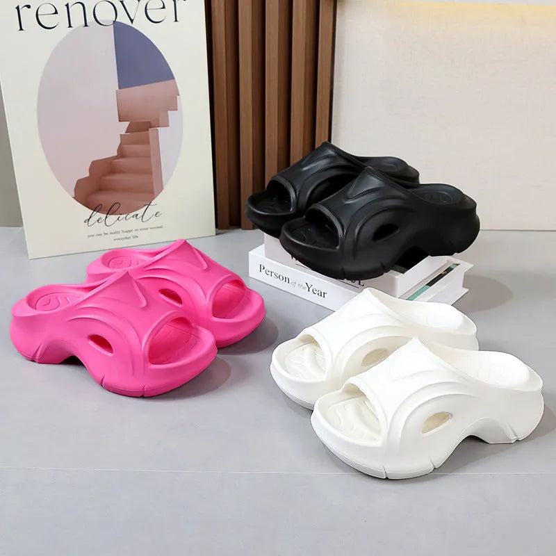 Women's white thick-soled EVA slippers with round toe on a beach background.