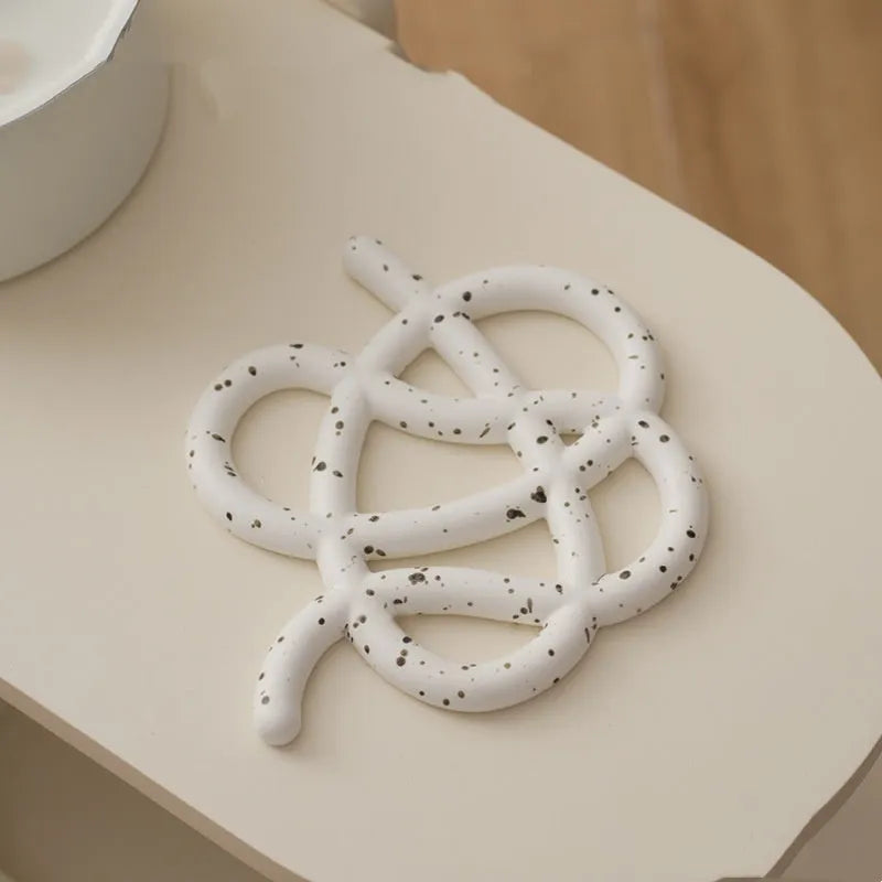Ceramic heatproof mat in an irregular shape on a kitchen countertop.