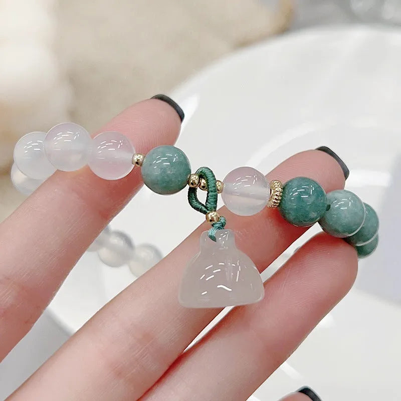 Close-up of a women's retro style agate bracelet with a lotus seedpod design.