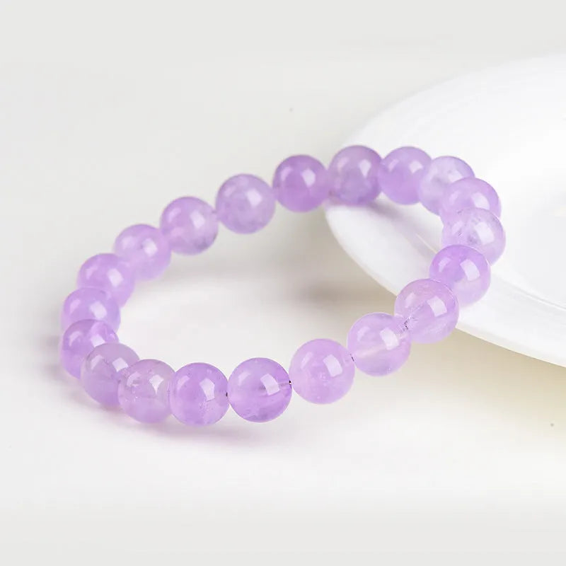 Lavender round amethyst crystal bead bracelet with water ripple design on a wrist.