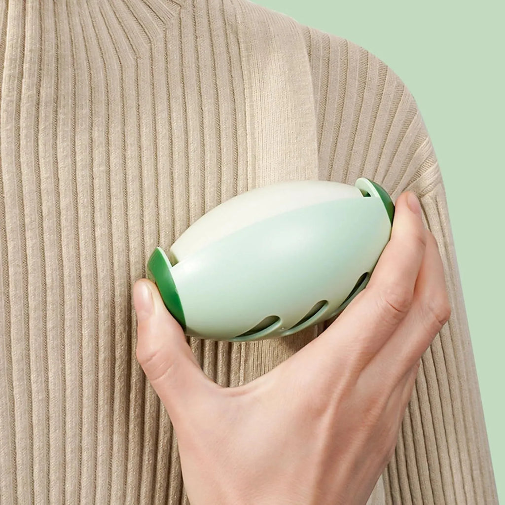 Green or white reusable gel lint roller ball for pet hair removal on fabric.