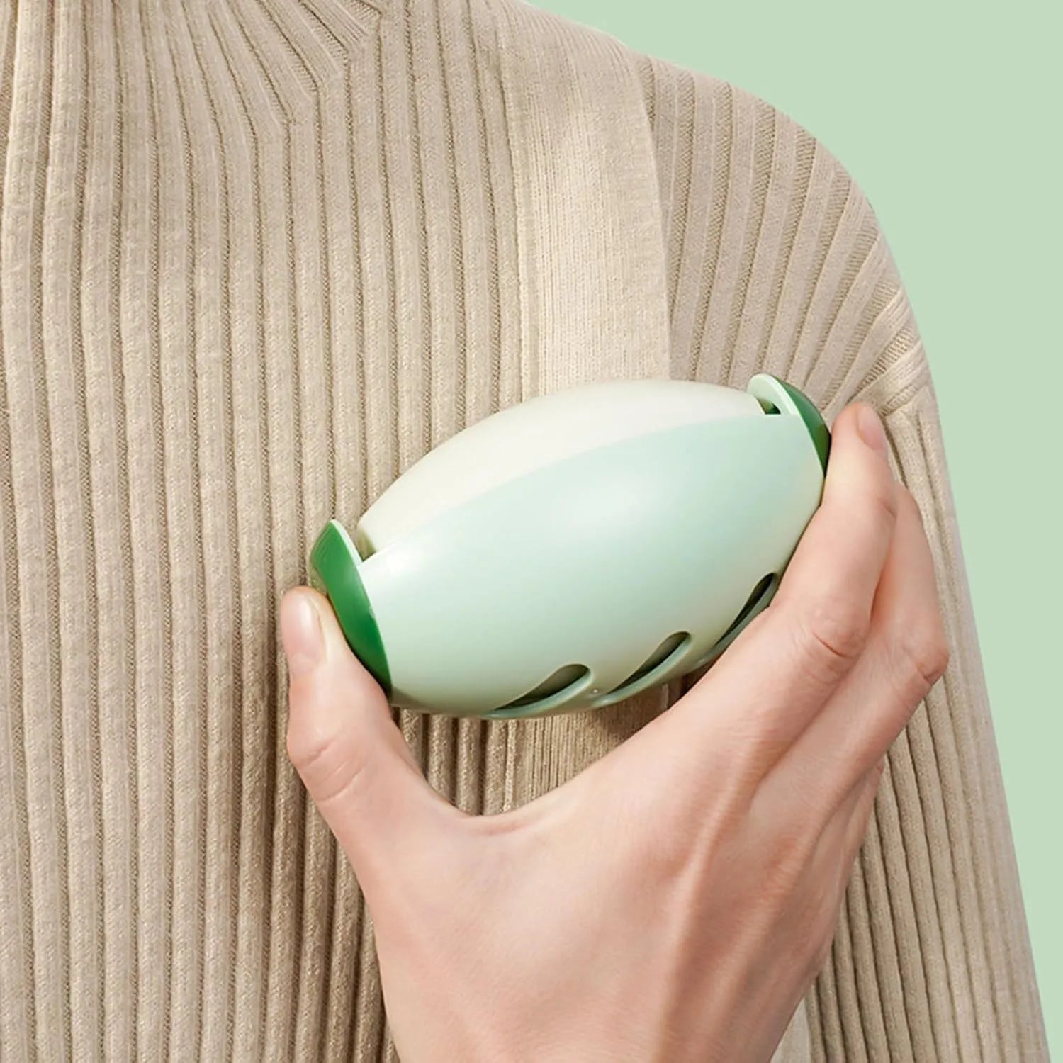Green or white reusable gel lint roller ball for pet hair removal on fabric.
