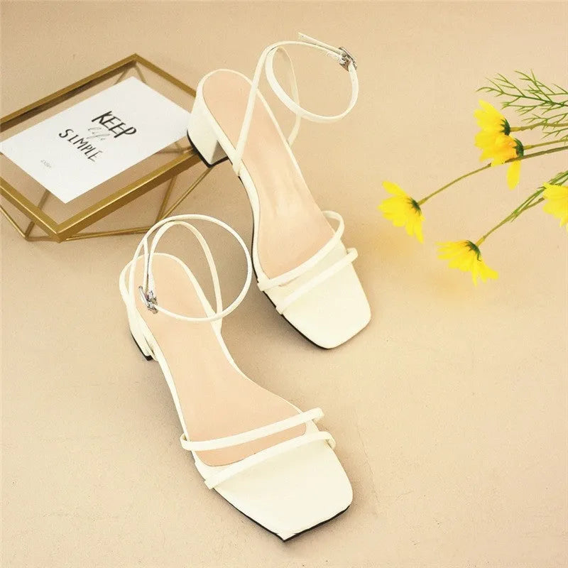 Beige women's stiletto sandals with a chunky heel, square toe, and an ankle buckle strap.