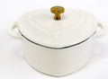 Heart-shaped cast iron enamel stew pot in Milk White with lid on a stovetop