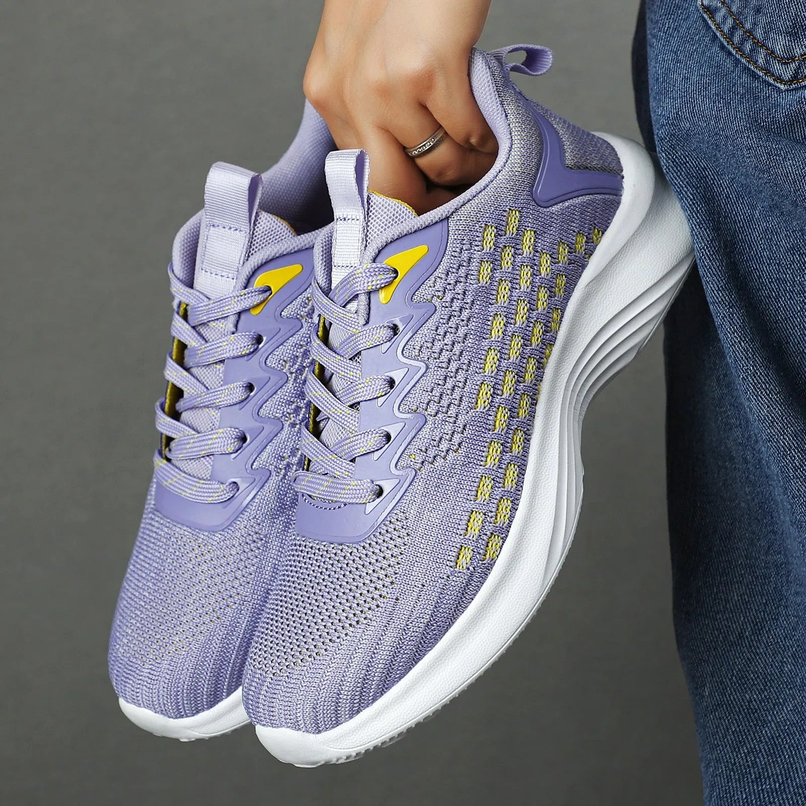 Women's lavender purple flyknit running shoes with mesh upper and striped pattern on a white background.