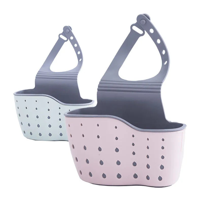 Three plastic kitchen sink storage racks in beige light blue and light pink on a draining board