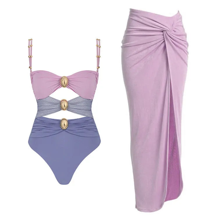 Women's solid colour one-piece swimsuit with detachable skirt and gold button detail.