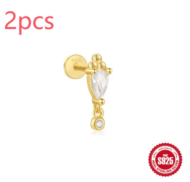 Close-up of a gold-coloured S925 sterling silver ear stud with a XINGX pattern inlay and a thin dangling tassel.