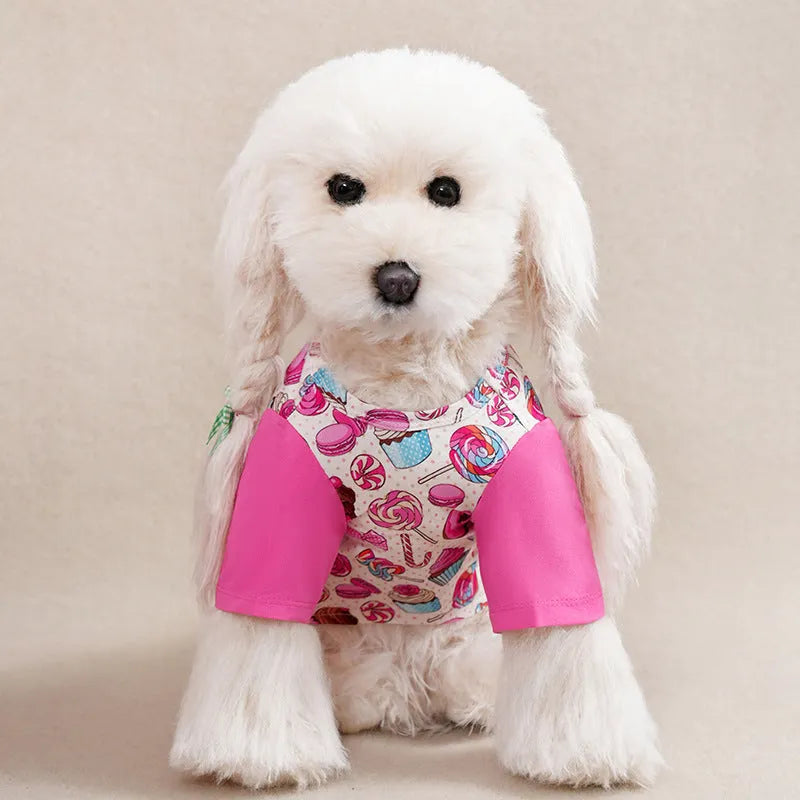 A small dog wearing a colourful, printed polyester t-shirt, showing the full chest design and fit.