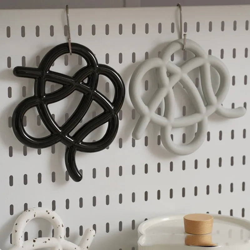 Ceramic heatproof mat in an irregular shape on a kitchen countertop.