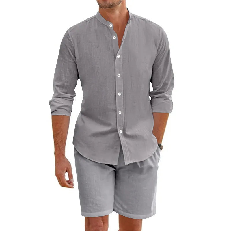 Men's dark grey linen blend summer suit with button-down short sleeve shirt and drawstring shorts.