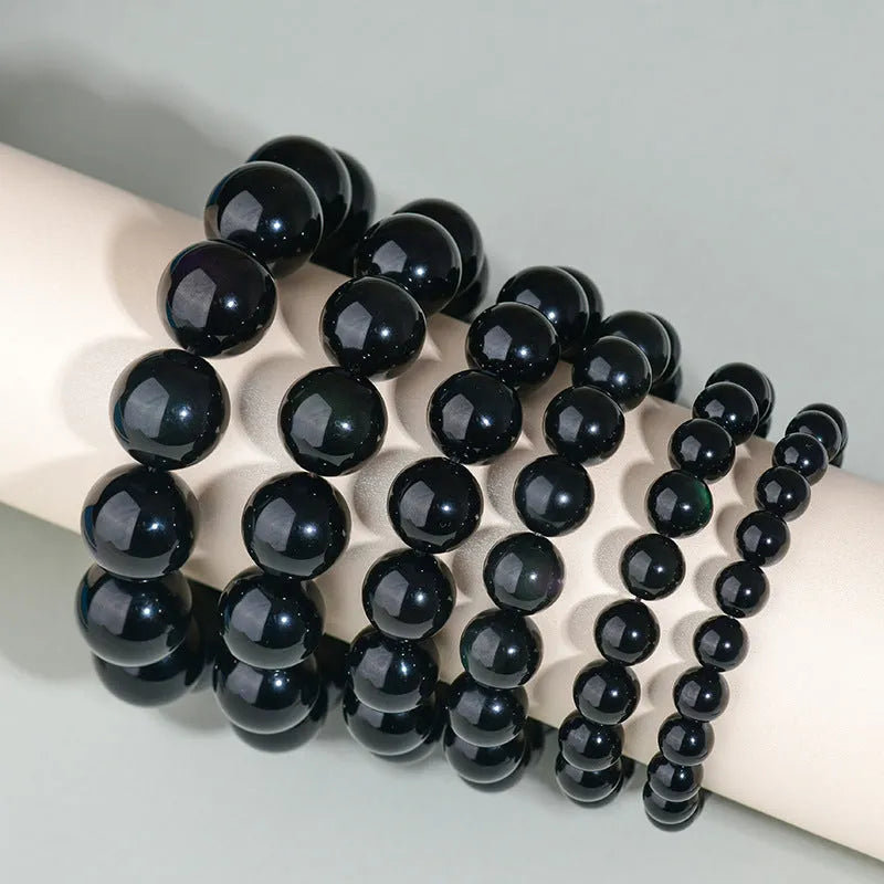 Hand-woven obsidian bracelet with round crystal beads in black stone variations including rainbow eye obsidian
