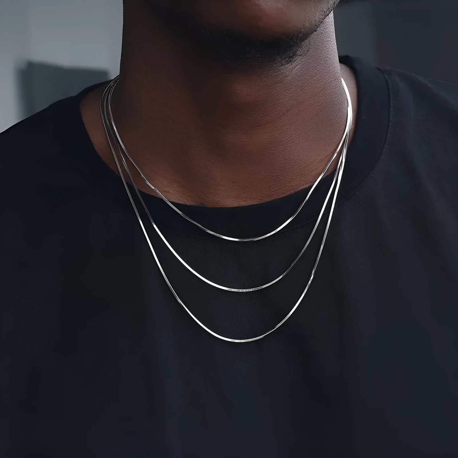S925 sterling silver plated platinum necklace with fine snake bone chain in silver on neutral background