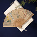 Traditional Chinese embroidered silk folding fan with bamboo frame showing detailed Su embroidery pattern